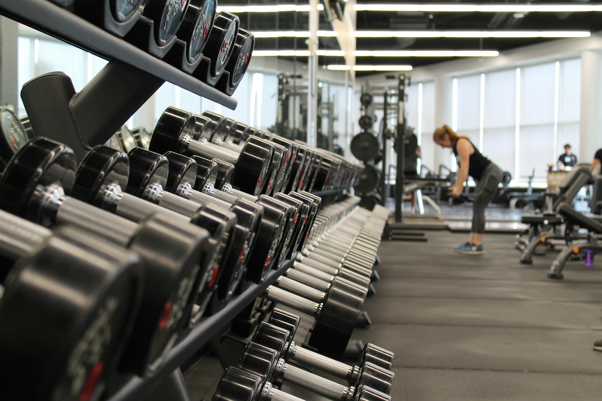 Rows of dumbbells beside a gym training floor